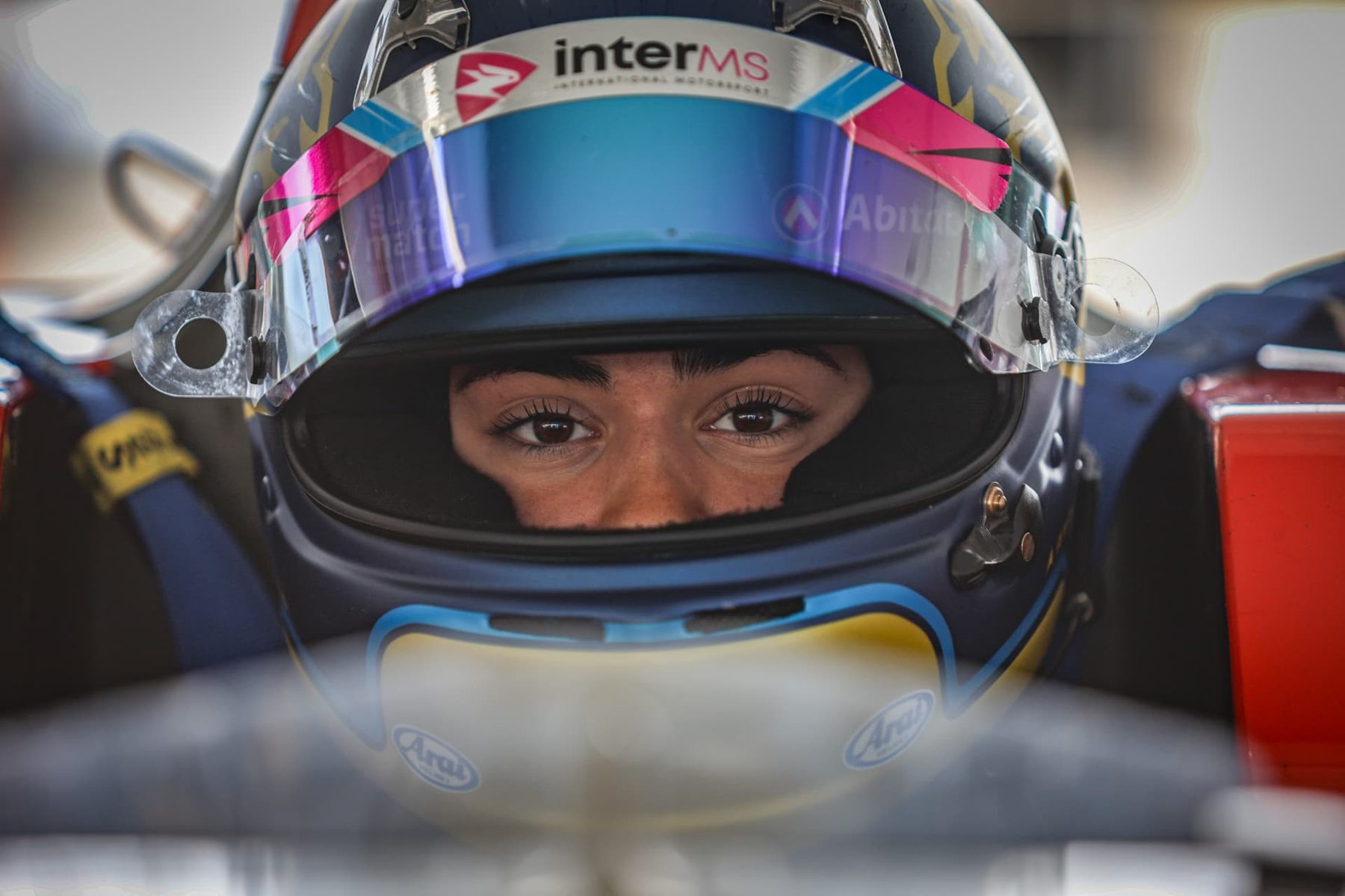 Close-up of Maite in her helmet, in the cockpit