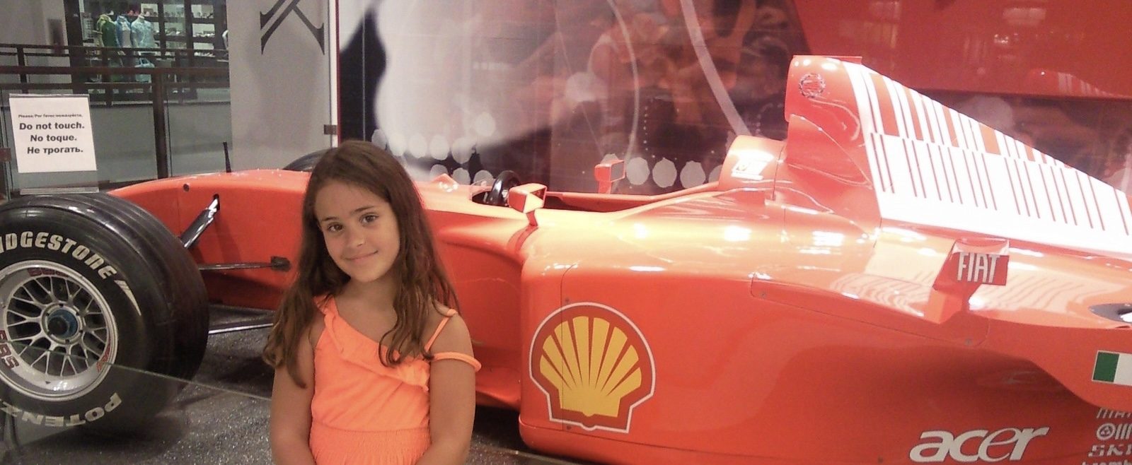 Young Maite next to a Ferrari Formula 1 car